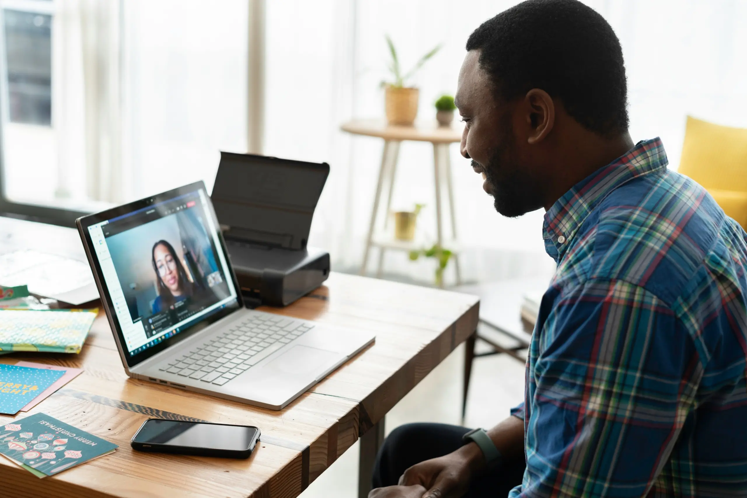 man on a video call on his computer while working at a desk