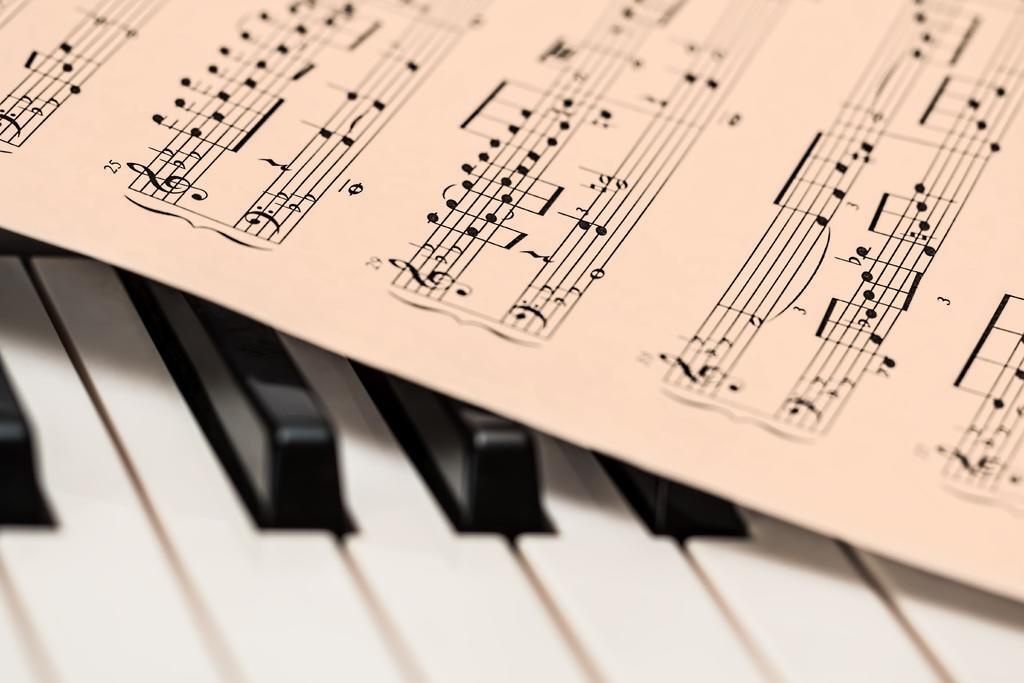 sheet music placed over a piano